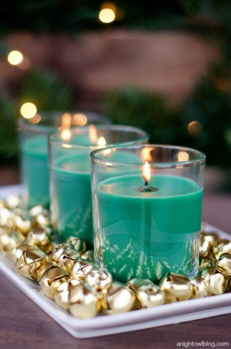 Velas azul Tiffany en un plato blanco con cascabeles dorados