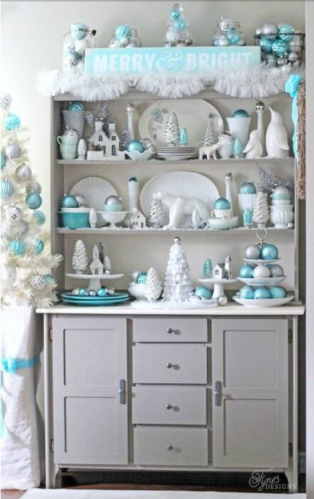 Mueble blanco de cocina decorado con platos blancos y esferas turquesas