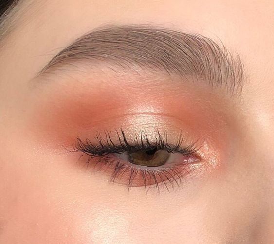 Maquillaje de ojos en tono coral con párpado perla y cejas suaves