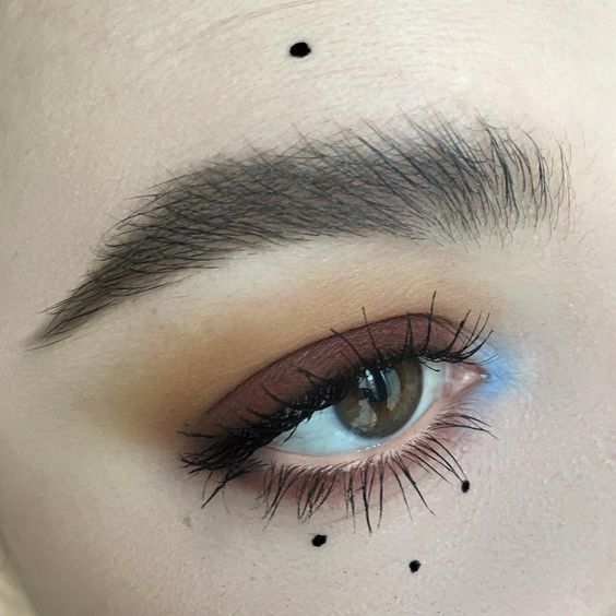 Maquillaje de ojos sencillo con ahumado tenue, sombra café en el párpado, sombra azul en el lagrimal y puntos de delineador