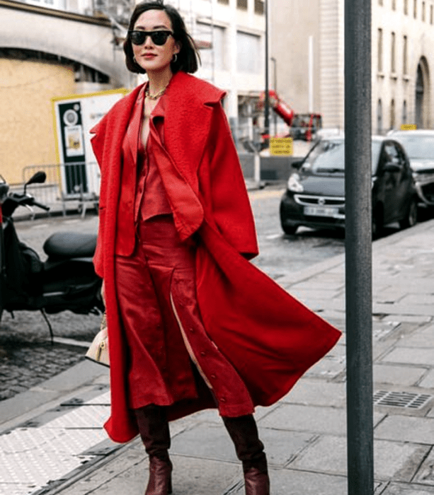 mujer de cabello corto con abrigo rojo, top rojo de satén y falda de satén roja