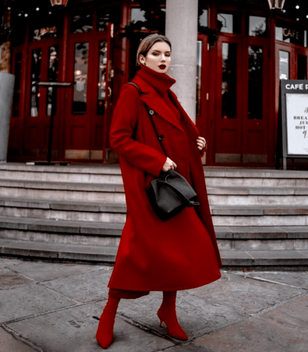 mujer de cabello castaño con suéter de cuello alto rojo, abrigo rojo, y pantalones rojos