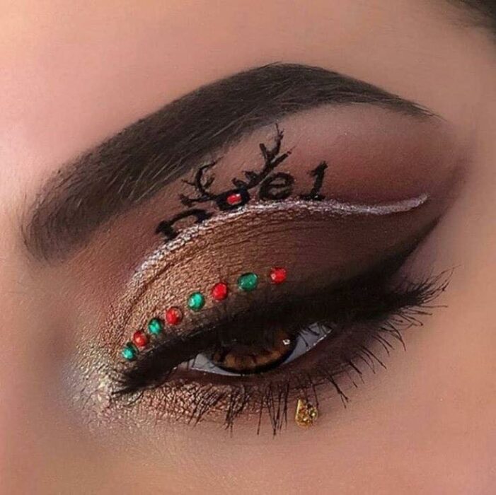 Chica con maquillaje de ojos en color café, delineado blanco y detalles en rojo; Maquillajes lindos para celebrar Navidad
