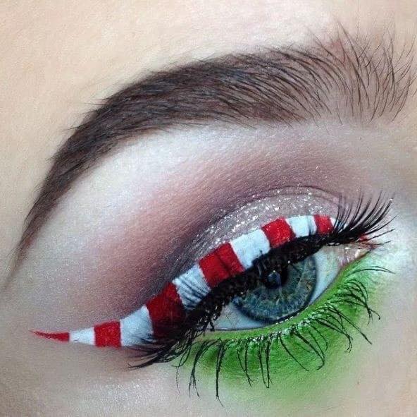 Chica con maquillaje de ojos delineado en color blanco, rojo y verde inspirado en El Grinch; Maquillajes lindos para celebrar Navidad