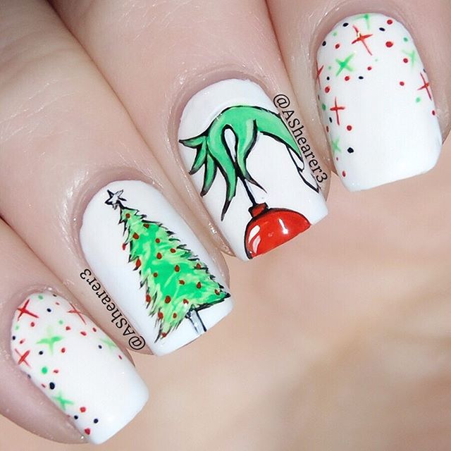 Uñas pintadas con base blanca decoradas con esferas de colores y alusivas al Grinch; diseños de manicuras navideñas
