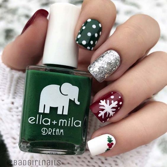 Uñas pintadas en tonos plata, rojo y verde, decoradas con copos blancos; diseños de manicuras navideñas