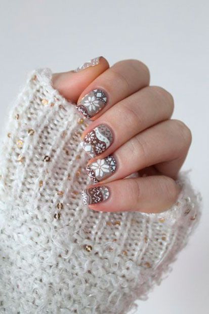 Uñas en tonos neutros decoradas con motivos inspirados en suéteres; diseños de manicuras navideñas