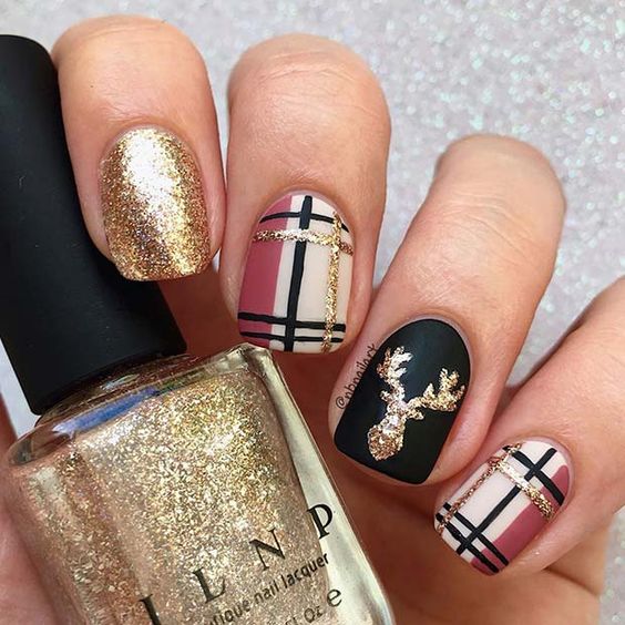 Uñas en tonos dorados y negros decoradas con renos; diseños de manicuras navideñas