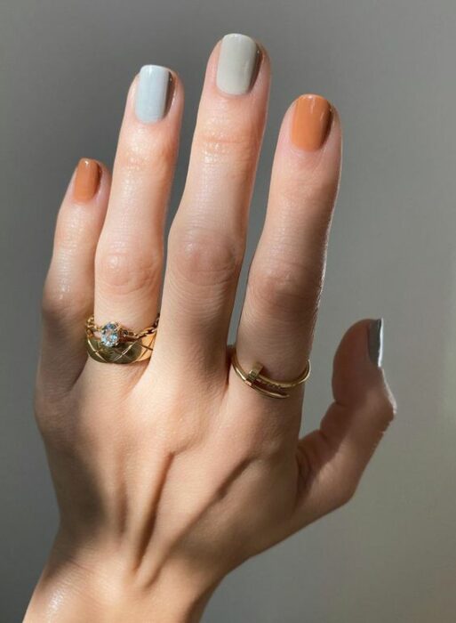 Manicura en varios colores como gris, azul y naranja