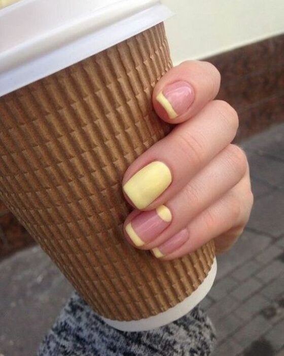Manicura con detalles en color amarillo y fondo nude