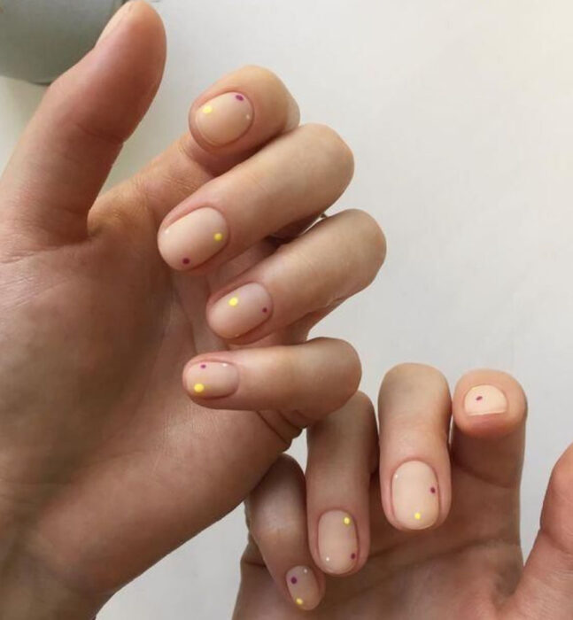 Manicura con fondo nude y puntos dorados