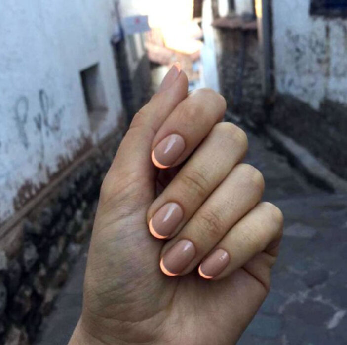 Manicura con fondo nude y estilo francés en color naranja