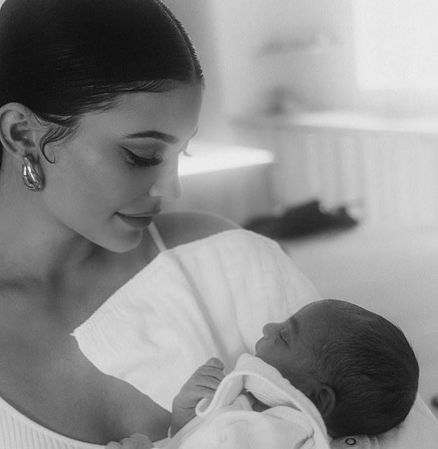 Kylie Jenner sosteniendo a su sobrino Psalm en brazos mientras lo mira fijamente 