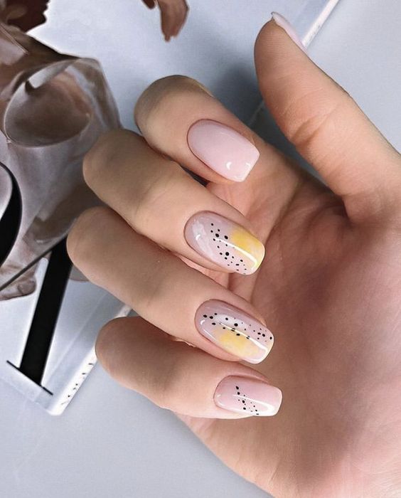 Manicura en color mostaza con fondo color nude y puntitos negros