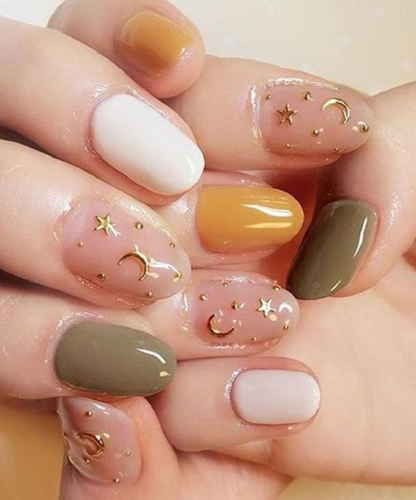 Manicura en color mostaza con verde, blanco y detalles de estrellas de color dorado