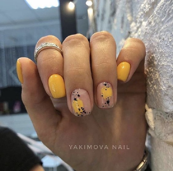 Manicura en color mostaza con detalles en nude y puntitos negros