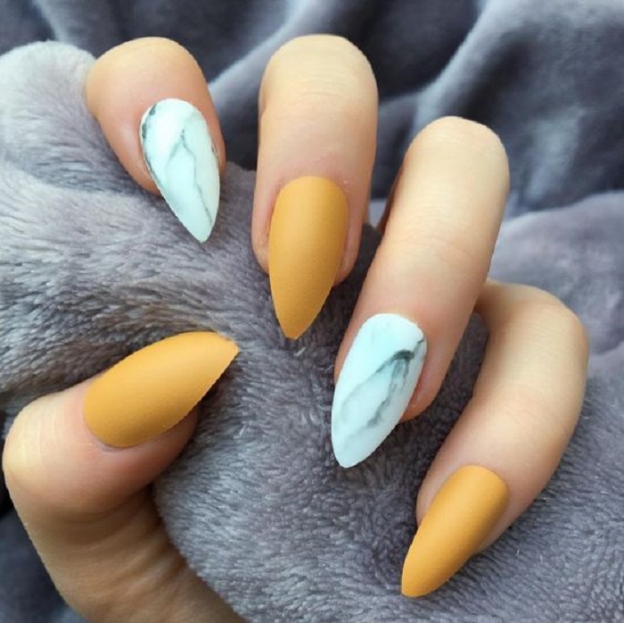 Manicura en color mostaza con uñas en tono mármol blanco todas en efecto mate