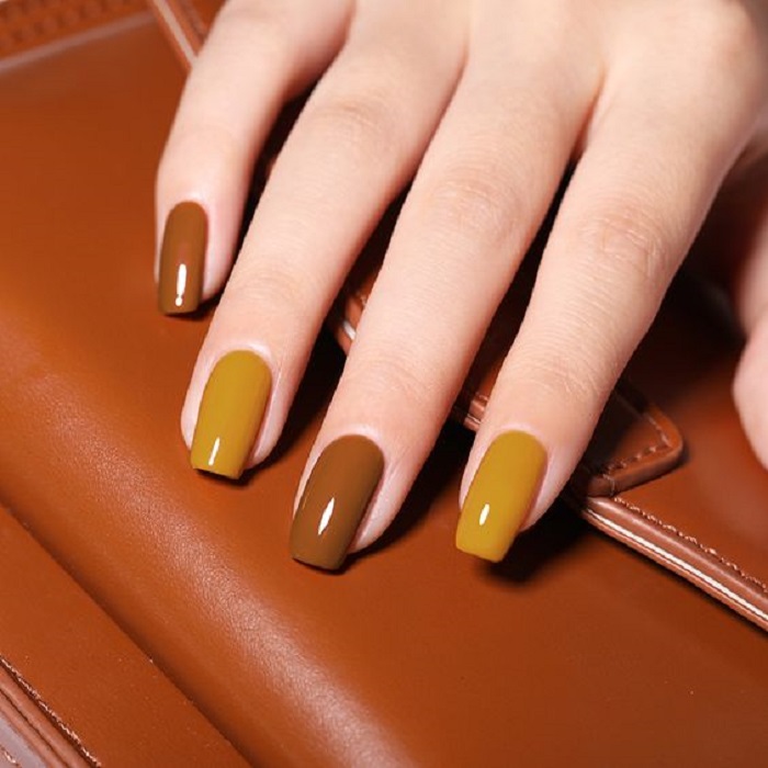 Manicura en color mostaza con uñas color café con brillo