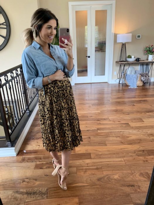 Chica usando un outfit de maternidad de falda con blusa de mezclilla y zapatos color nude