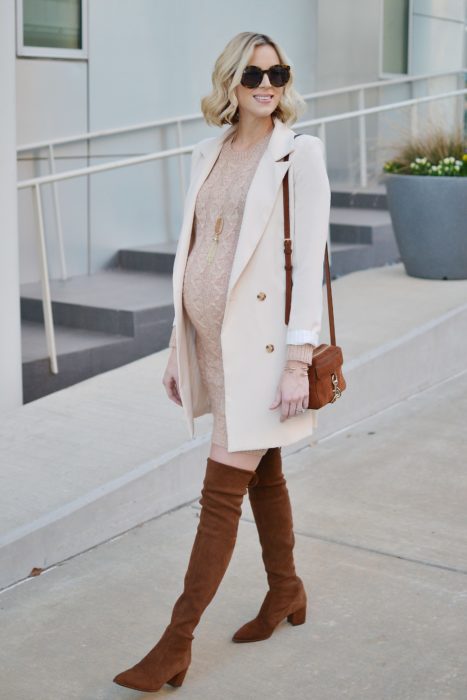 Chica usando un outfit de maternidad de vestido con saco largo y botas hasta los muslos