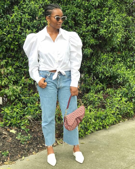 Chica usando una camisa blanca con jeans y flats