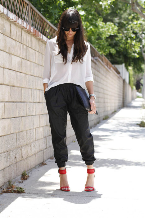Chica usando una camisa blanca de botones con pantalón negro y zapatos rojos