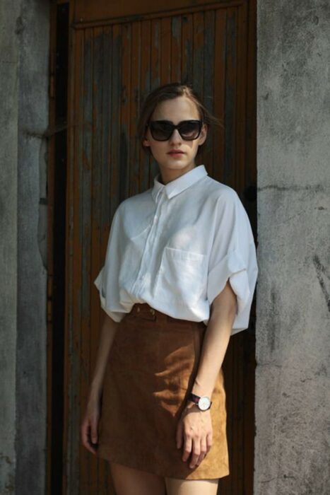 Chica usando una camisa blanca con una falda marrón