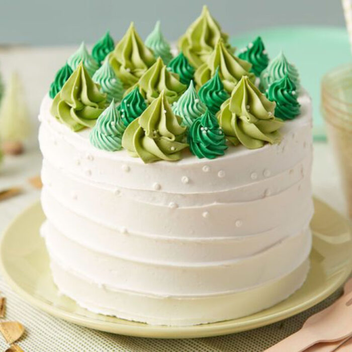 Pastel de Navidad de vainilla con decoración de pinos de distintos colores