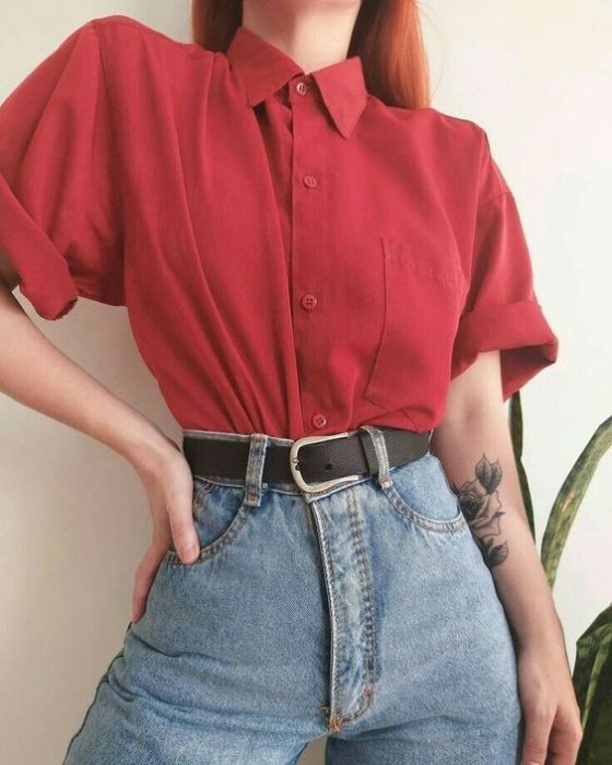 Chica usando mom jeans, cinturón negro y camisa color rojo cereza de manga corta