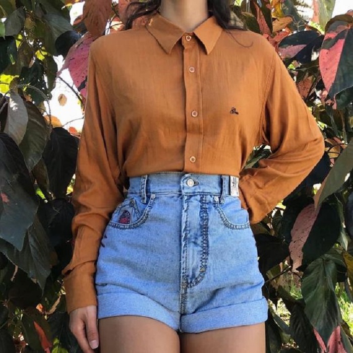 Chica usando shorts denim y camisa color mostaza de manga larga