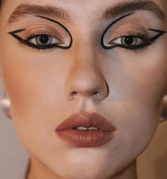 chica de ojos azules con delineado negro gráfico estilo setentas con labial color café nude mate