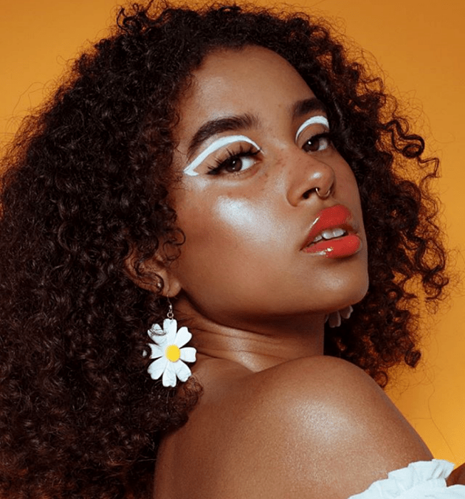 chica morena con delineado grueso gráfico blanco y pestañas postizas