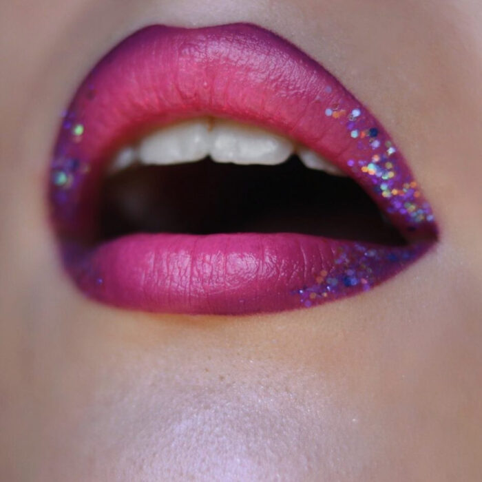 Maquillaje artístico de labios por maquilladora Tatiana Rose; boca con labial rosa con orillas moradas y brillo