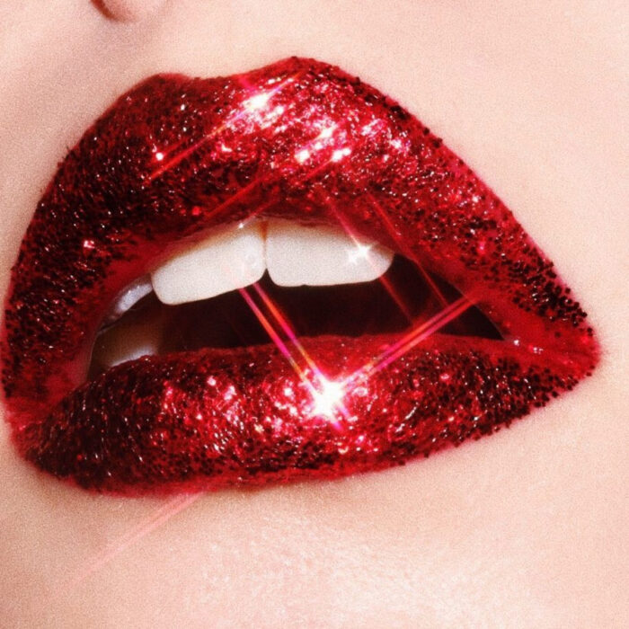 Maquillaje artístico de labios por maquilladora Tatiana Rose; boca con labial rojo intenso y brillos rojos