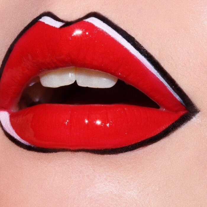 Maquillaje artístico de labios por maquilladora Tatiana Rose; boca con labial rojo con efecto de cómic, contorno negro y blanco, gloss