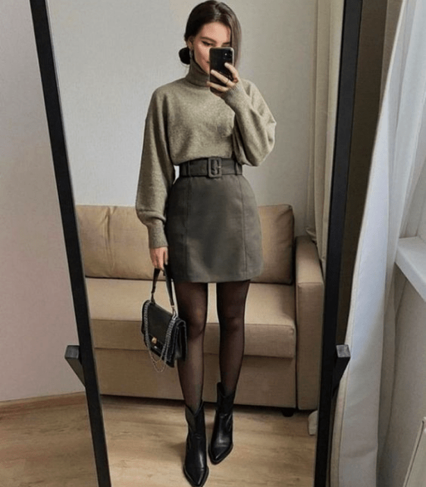 chica con sudadera verde, minifalda de pana, medias negras y botines