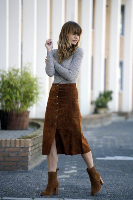 Outfit de pana tipo falda midi color caki con abertura en medio, botines camel y blusa gris de manga larga