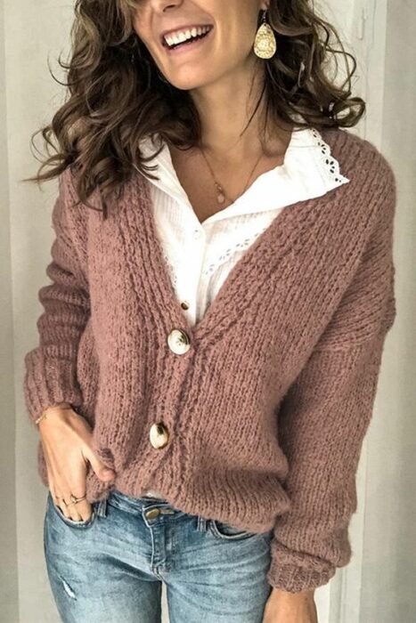 Chica usando cardigan corto de botones color rosa palo, con camisa de cuello blanco y jeans