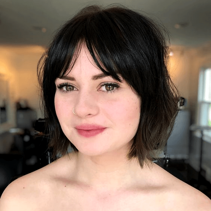 chica de cabello oscuro usando un corte de cabello estilo french bob, bob francés