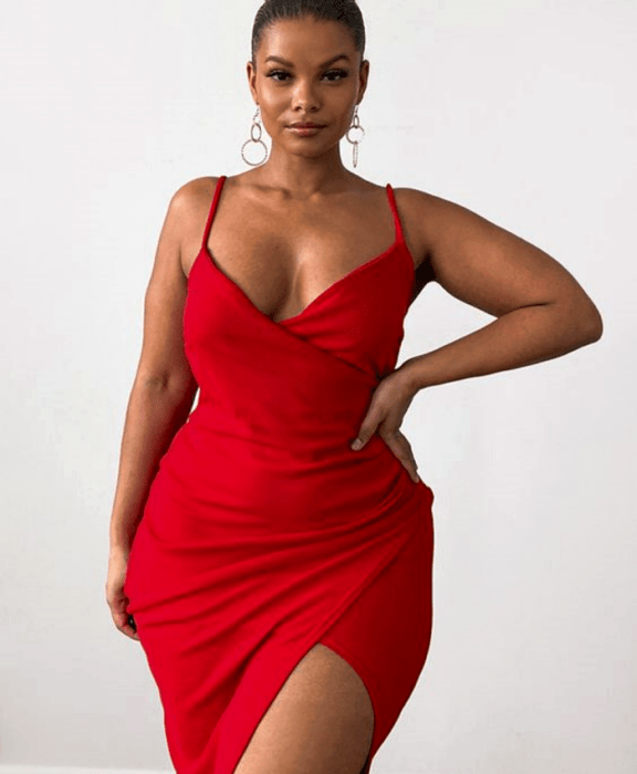chica curvy morena usando un vestido sexy rojo de tirantes, con escote en V, ajustado a la cintura y con abertura en la pierna
