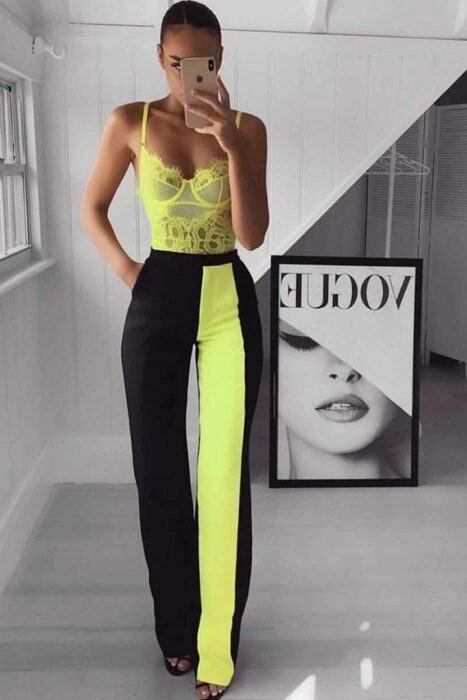 Chica usando un pantalón de color negro en combinación con tonos neón