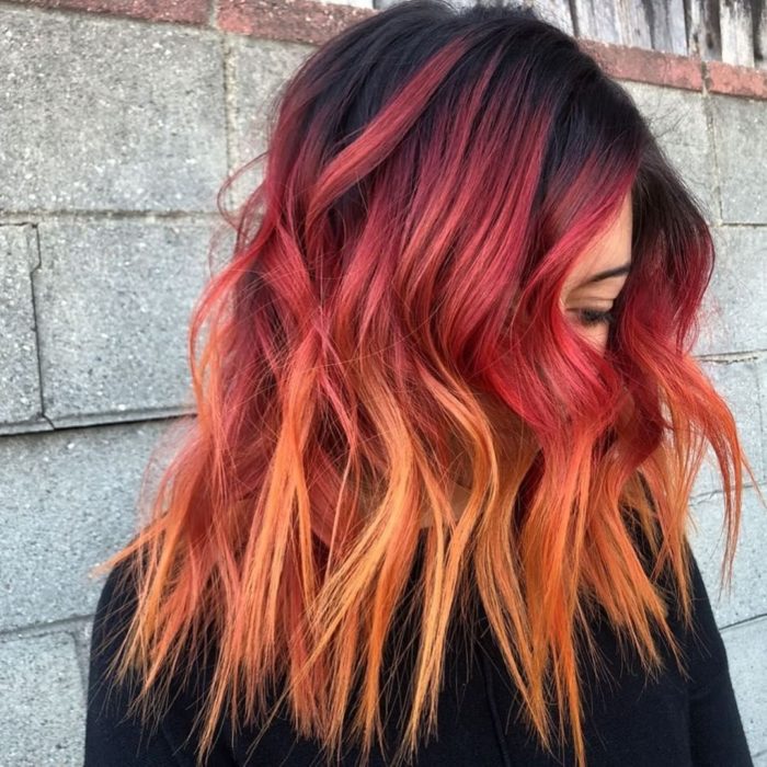 Chica con el cabello teñido de color rojo con puntas amarillas