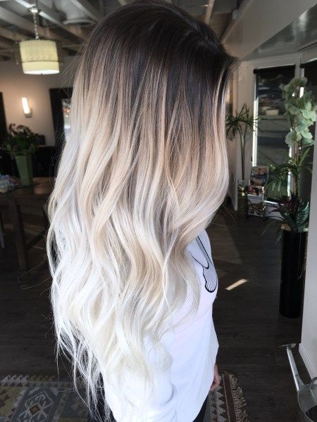 Chica de cabello largo degradado de oscuro en la parte superior a blanco 'icy blonde' en las puntas