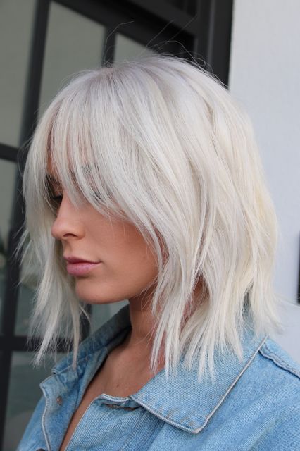 Chica con chaqueta de mezclilla y melena corta degrafilada en tono blanco 'icy blonde'