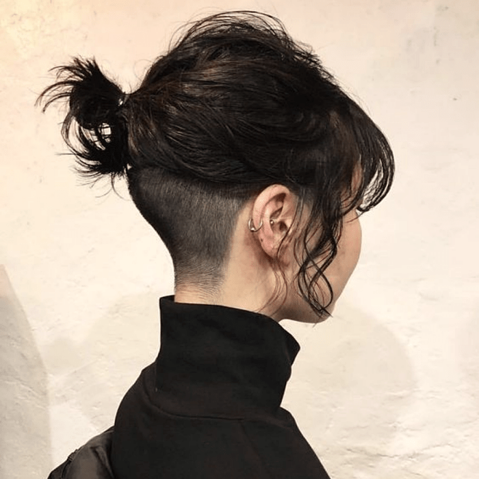 chica con cabello corto negro, rapada en la nuca con top de cuello alto color negro