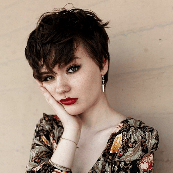 chica de cabello corto castaño con corte pixie, volumen al frente y top de flores con cuello en v