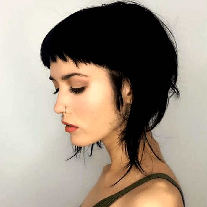 chica de cabello oscuro con corte de cabello estilo radical, fleco super corto y capas en ángulo