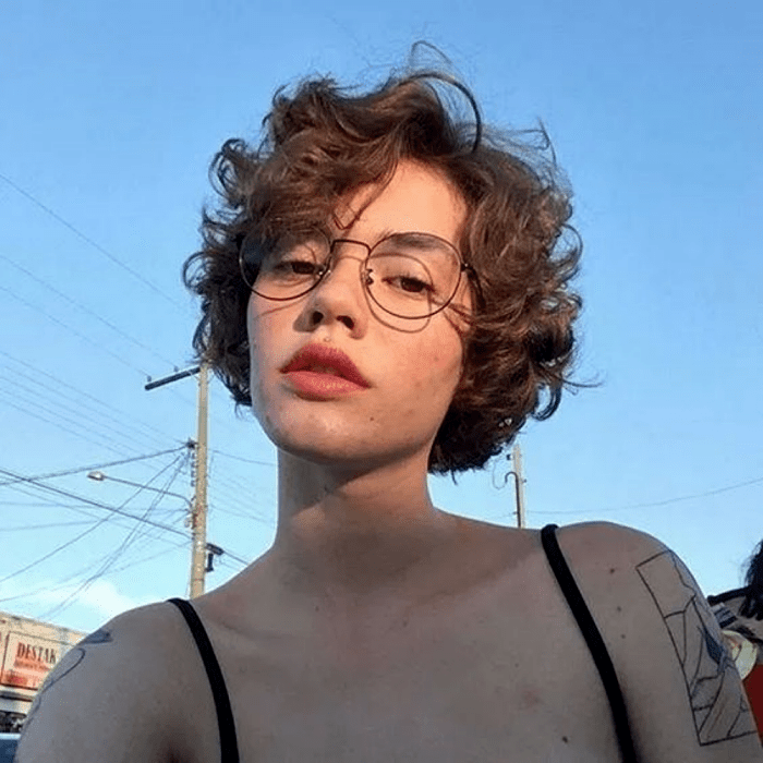 chica de cabello chino con corte de cabello estilo bob de melena corta