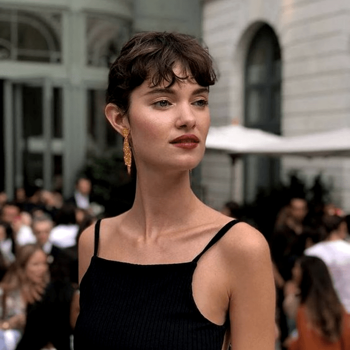 chica de cabello castaño con corte de cabello estilo super corto, melena rasa y fleco pequeño al frente