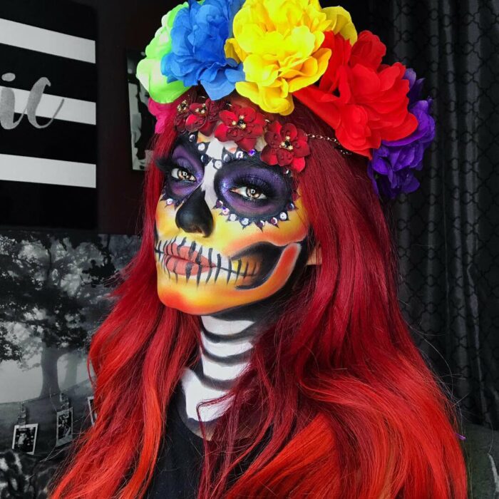 Chica con maquillaje de Catrina en colores rojo, morado y amarillo